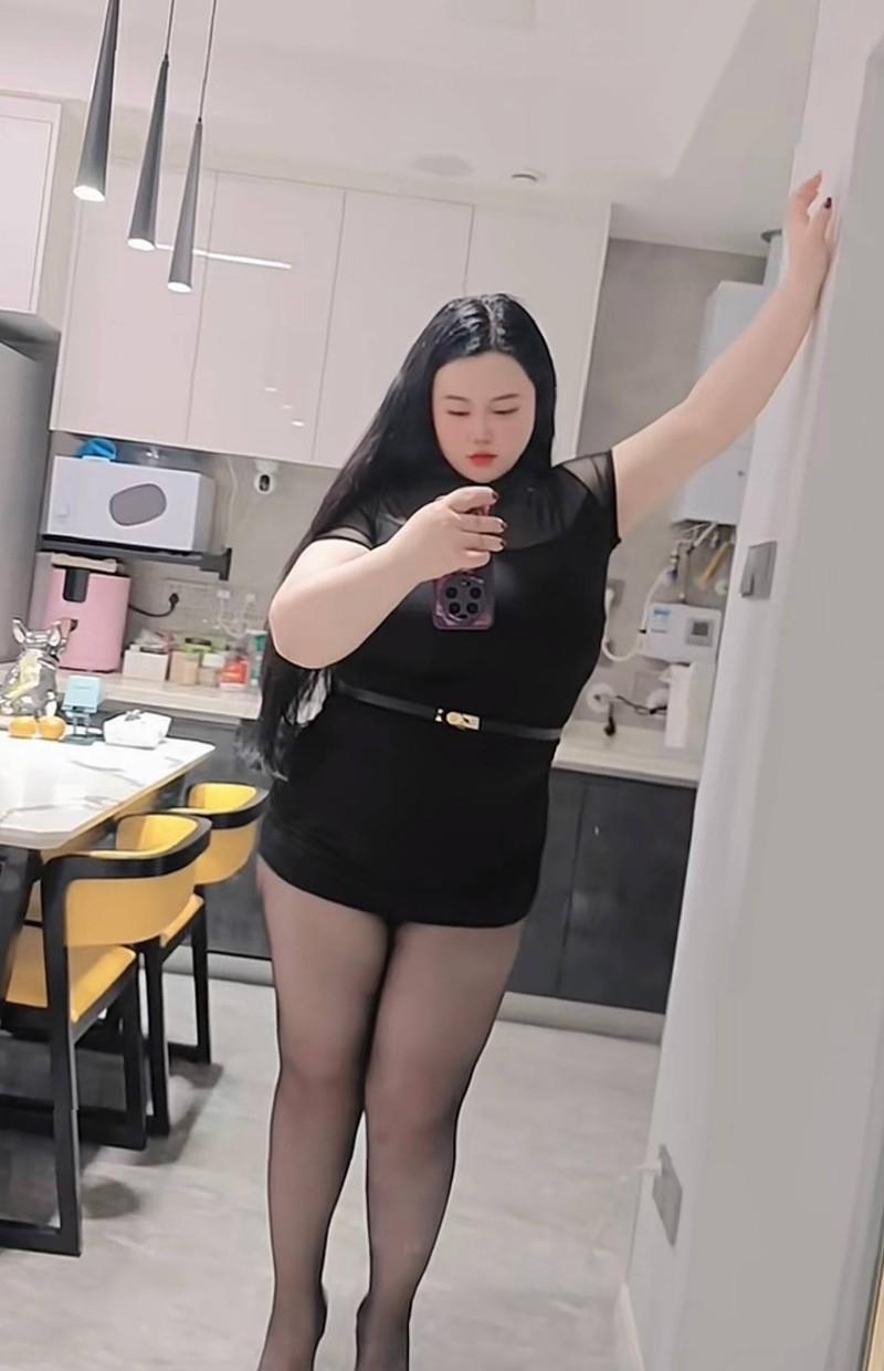福福肉肉穿黑色连衣裙站在室内