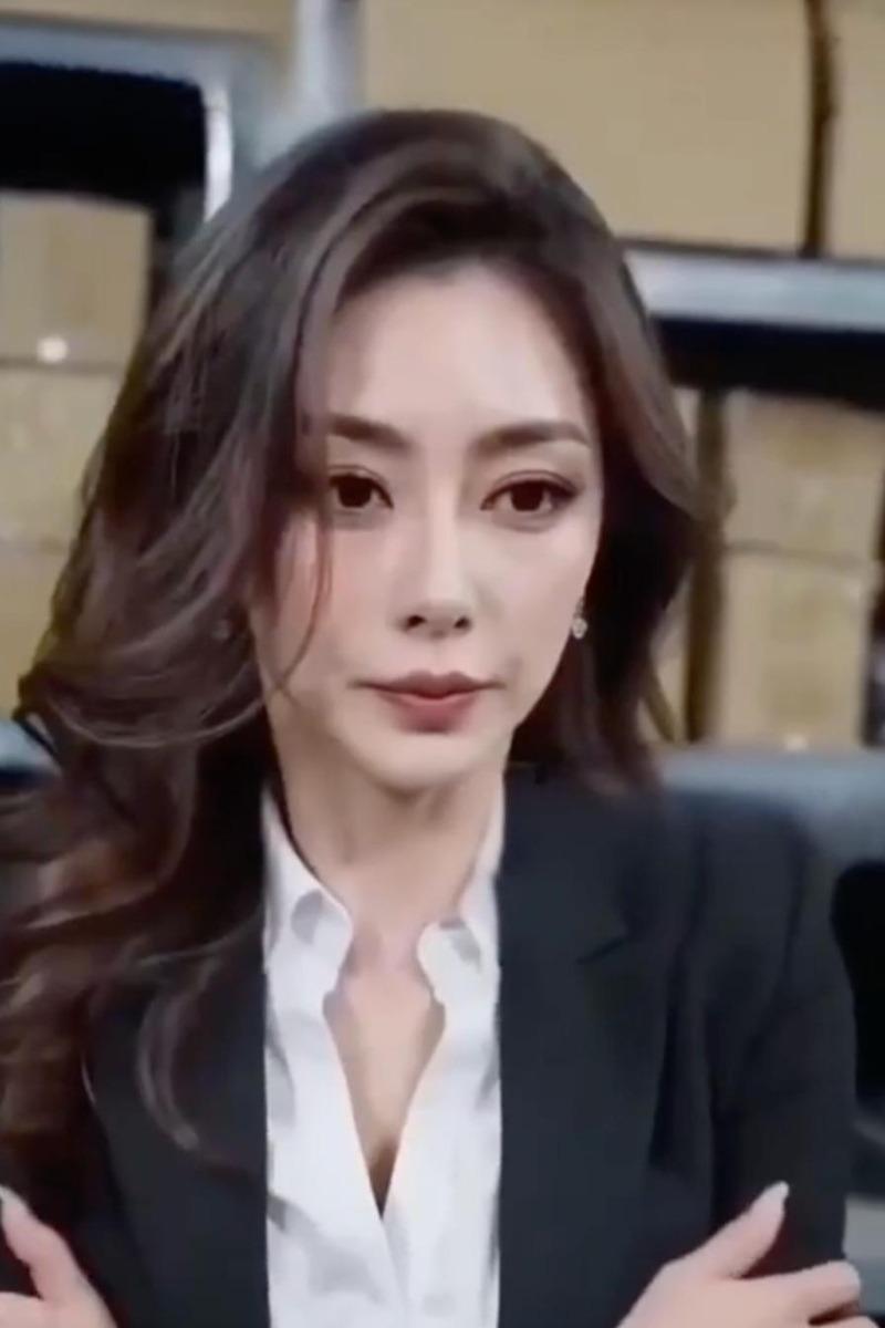 身穿深色西装的女上司坐在会议桌前