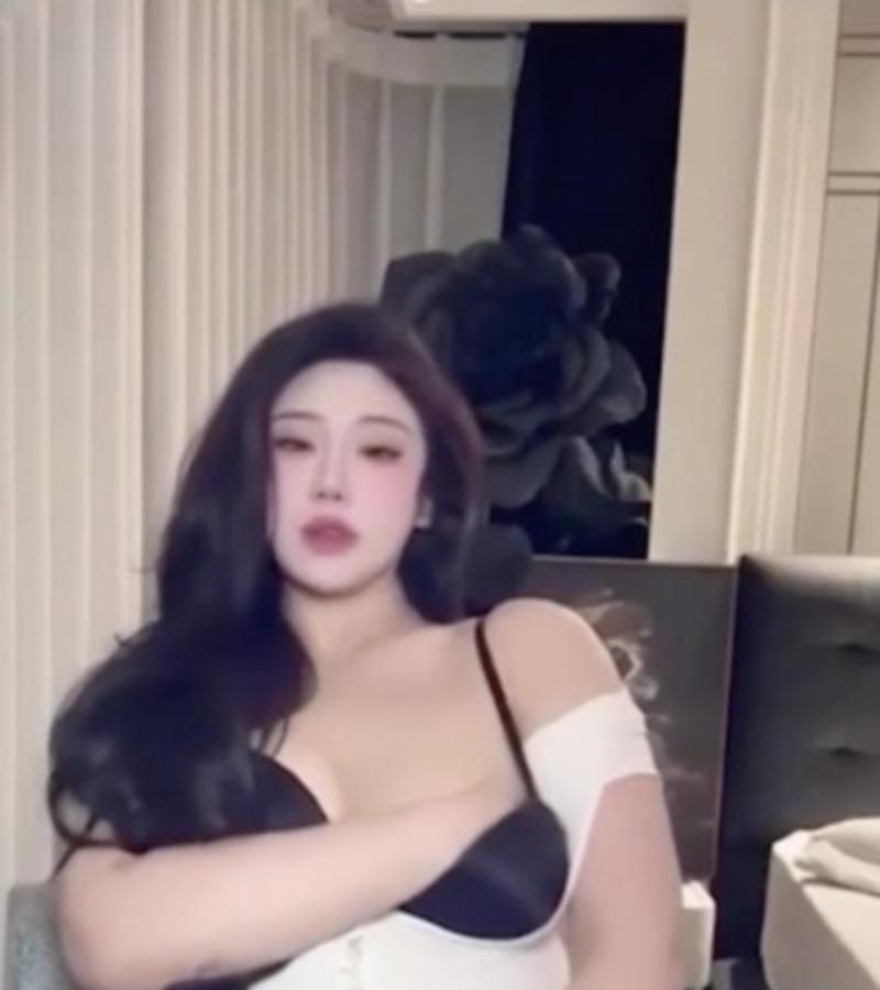 亚亚亚辰穿黑白上衣坐在灰色座椅前