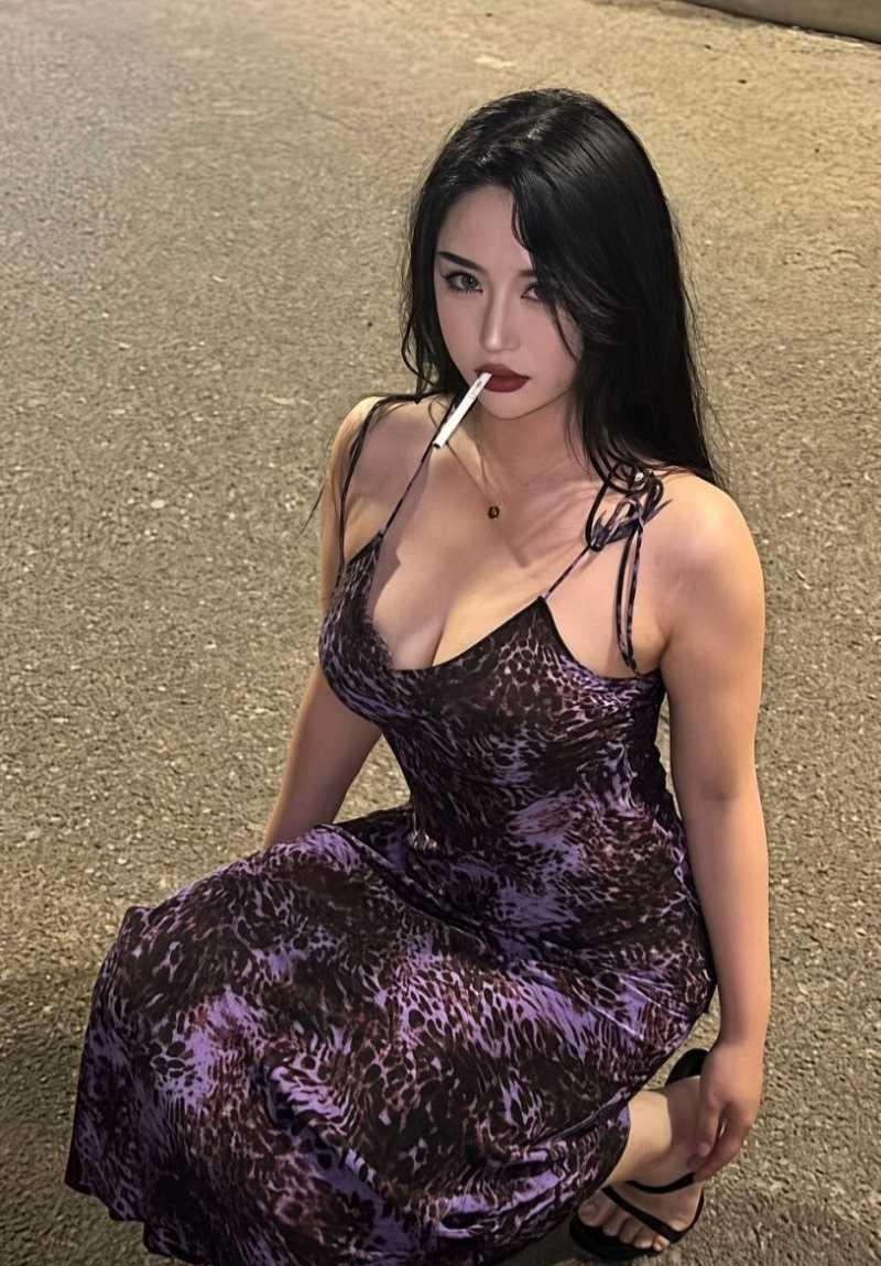 王依婷穿紫色长裙坐在暖色墙面前