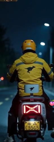 林浩穿黄色制服夜间骑车前往任务地点