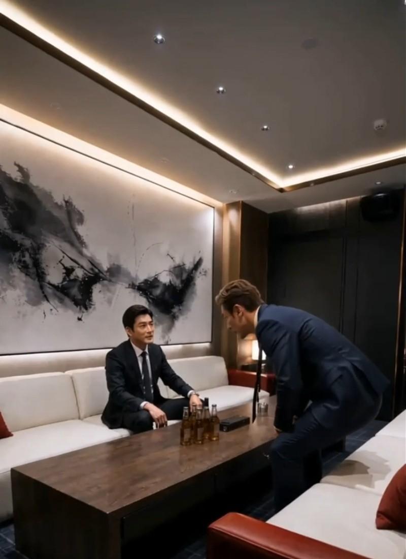 两名西装男子在会客厅隔桌交谈