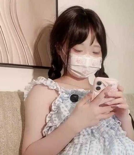 推特芊芊穗穿蓝白格纹裙坐在沙发上看手机